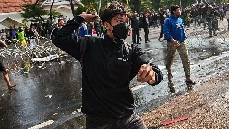 Protesters and police clash after death of taxi driver in Indonesia